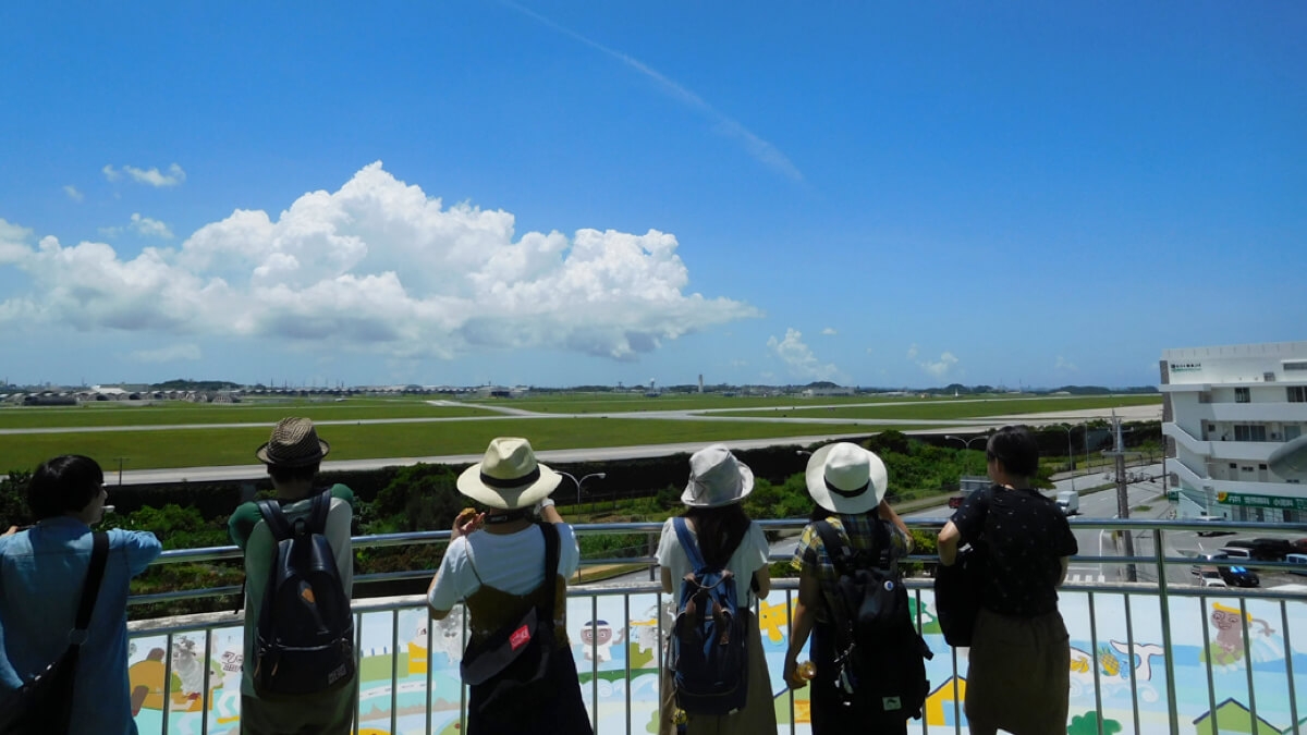 毎年、夏休みに実施している沖縄での研究合宿にて、嘉手納飛行場視察の様子