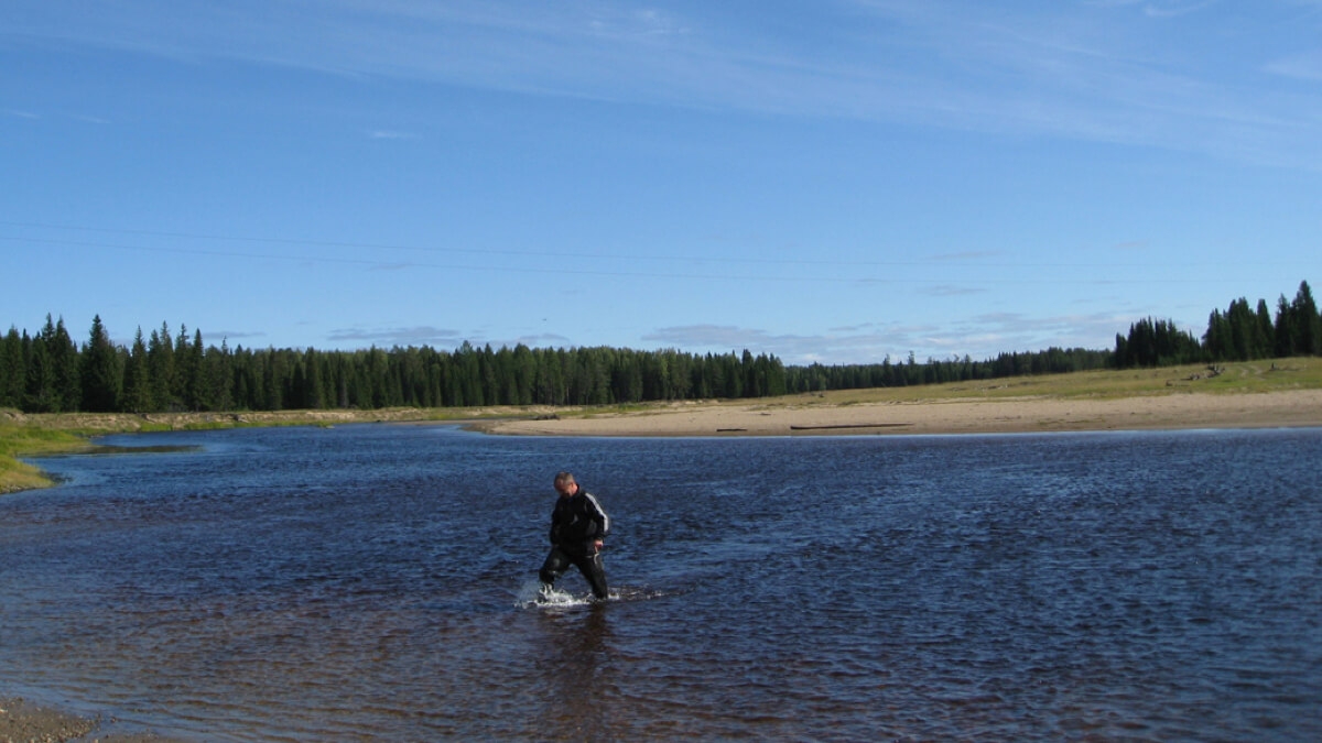 ロシア北部アルハンゲリスク州でのフィールド調査時の様子。橋がないため、事前に水深を測り、車で川を渡る。（2015年、撮影：中堀正洋）