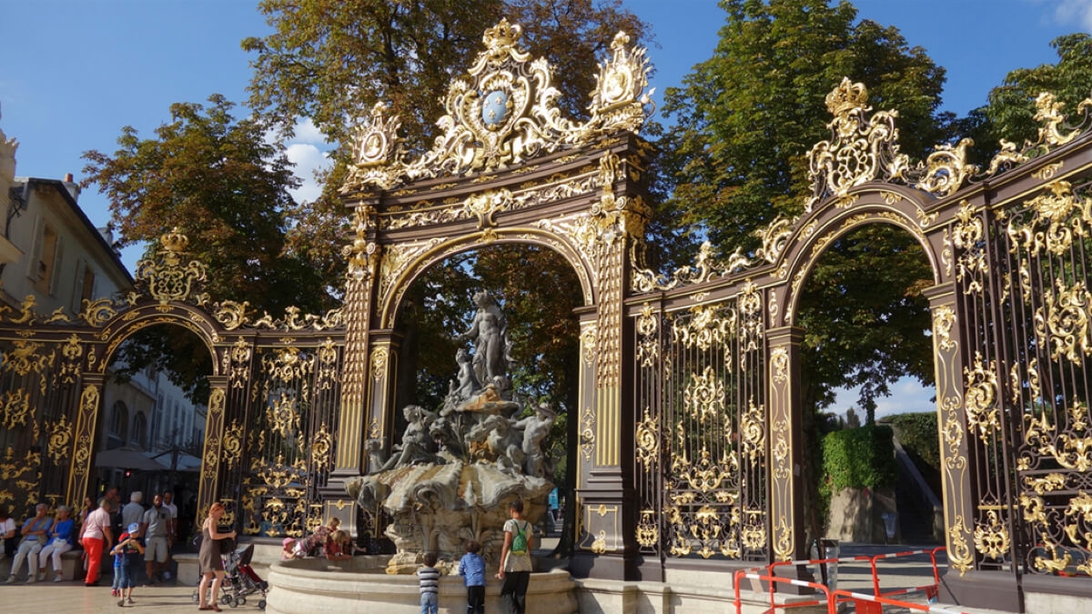 ロレーヌの中心都市ナンシーにあるスタニスラス広場（世界遺産）の様子​。ロココ調装飾がほどこされた黄金の鉄門とアンフィトリテの噴水がある。
